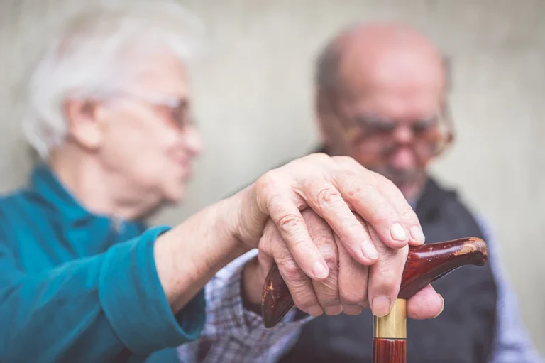 parkinsons study - sad elderly couple holding hands
